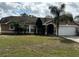 Charming single-story home featuring a well-manicured lawn and lush tropical landscaping at 121 Loma Bonita Dr, Davenport, FL 33837