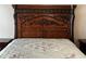 Ornate wood carved headboard of a bed featuring a patterned bedspread at 121 Loma Bonita Dr, Davenport, FL 33837