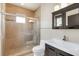 Bathroom with a tiled shower featuring glass door and built-in seat and dark wood vanity at 135 James Pl, Maitland, FL 32751