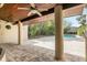 Covered patio featuring brick floors, fans, columns and a serene backyard pool at 135 James Pl, Maitland, FL 32751