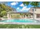 Backyard pool with brick trim, lush green lawn, solar panels and door access to the house at 135 James Pl, Maitland, FL 32751