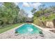 Inviting backyard pool is surrounded by lush landscaping, beautiful brick pavers, and space for relaxing at 135 James Pl, Maitland, FL 32751