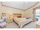 Cozy bedroom with floral wallpaper, ceiling fan, and view of the outdoor pool at 14067 Weymouth Run, Orlando, FL 32828