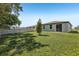 Lush backyard featuring a privacy fence and rear building elevation with a sliding glass door at 1522 Mermaid Way, Haines City, FL 33844