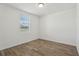 A bright and airy bedroom features neutral-toned walls and wood-look floors with a window at 1522 Mermaid Way, Haines City, FL 33844