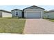 Charming single-Gathering home features a brick driveway, a 2-car garage, and well-maintained lawn at 1522 Mermaid Way, Haines City, FL 33844