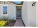 Inviting entryway with a gray front door, brick walkway, window and manicured landscaping at 1522 Mermaid Way, Haines City, FL 33844