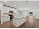 A modern kitchen features a central island, white cabinets, and sleek, stainless steel appliances at 1522 Mermaid Way, Haines City, FL 33844