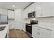 Modern kitchen features stainless steel appliances, white cabinetry, and quartz countertops at 1522 Mermaid Way, Haines City, FL 33844
