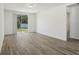 Spacious living room with wood-style floors, sliding glass door leading to backyard, and white walls at 1522 Mermaid Way, Haines City, FL 33844