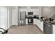 Contemporary kitchen featuring white cabinets, stainless steel appliances, and modern tile flooring at 1623 Mirabella Cir, Davenport, FL 33897