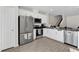 Modern kitchen with white cabinets, stainless steel appliances, tile flooring, and an open layout at 1623 Mirabella Cir, Davenport, FL 33897