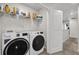 Bright laundry room features modern washer and dryer, with storage shelving for supplies at 1623 Mirabella Cir, Davenport, FL 33897