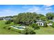 Aerial view featuring a home, pool area, mature landscaping, and water views from this luxurious real estate property at 17201 Magnolia Island Blvd, Clermont, FL 34711