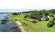 Waterfront estate with pool and dock on lush, green lawn extending to lake at 17201 Magnolia Island Blvd, Clermont, FL 34711