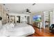 A bright bedroom with a large bed, wood floors, and a mirrored dresser with TV at 17201 Magnolia Island Blvd, Clermont, FL 34711