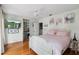 Bright bedroom with wood floors, a ceiling fan, and adjacent stone-accented staircase at 17201 Magnolia Island Blvd, Clermont, FL 34711