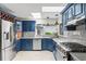 Well-lit kitchen with stainless steel appliances and blue cabinets at 17201 Magnolia Island Blvd, Clermont, FL 34711