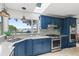 Modern kitchen featuring blue cabinets, stainless steel appliances and a lake view at 17201 Magnolia Island Blvd, Clermont, FL 34711