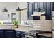 Modern kitchen with navy cabinets, stainless steel appliances, and stone countertops at 17201 Magnolia Island Blvd, Clermont, FL 34711