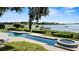 Stunning swimming pool and spa overlooking a serene lake, surrounded by manicured landscaping and lush greenery at 17201 Magnolia Island Blvd, Clermont, FL 34711