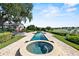 In-ground pool and spa are surrounded by lush landscaping and a serene lake view; ideal for relaxation at 17201 Magnolia Island Blvd, Clermont, FL 34711