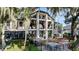 Rear view of home with large windows, deck, and outdoor dining area at 17201 Magnolia Island Blvd, Clermont, FL 34711