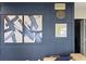 Close up of a blue wall with modern paintings and a clock at 17201 Magnolia Island Blvd, Clermont, FL 34711
