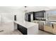 Bright kitchen featuring a quartz island, modern lighting, stainless steel appliances, and black and gold honeycomb backsplash at 17529 Eve Dr, Montverde, FL 34756
