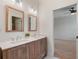 Bathroom featuring double sinks, a wood-framed mirror, and an adjacent bedroom at 1854 Robin Rd, Orlando, FL 32814