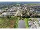 Scenic aerial shot of a neighborhood with swimming pools and a serene pond at 1938 Filly Trl, Oviedo, FL 32765