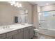 Bathroom with double vanity sinks, modern lighting, and a glass-enclosed shower-tub combo at 1938 Filly Trl, Oviedo, FL 32765