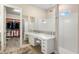 Bright bathroom featuring a vanity area, modern shower and a walk-in closet with custom shelving at 1938 Filly Trl, Oviedo, FL 32765