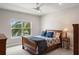 Bright bedroom with a sleigh bed, ceiling fan, and a large window overlooking tropical foliage at 1938 Filly Trl, Oviedo, FL 32765