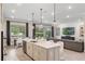 Bright open concept kitchen with a center island, pendant lighting and stainless steel appliances at 1938 Filly Trl, Oviedo, FL 32765