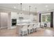 Bright, all-white kitchen with a large island, stainless steel appliances, and adjacent dining area at 1938 Filly Trl, Oviedo, FL 32765