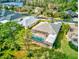 Aerial view of a home with a screened in pool and lush greenery, including a view of the nearby lake at 2439 Teton Stone Run, Orlando, FL 32828