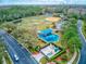 Aerial view of community park, playground, sports field, pond, and surrounding wooded area at 2439 Teton Stone Run, Orlando, FL 32828