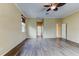 An inviting bedroom featuring wood-look flooring, neutral walls, and a glimpse of the ensuite bathroom and hallway at 2439 Teton Stone Run, Orlando, FL 32828