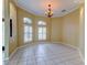 Elegant dining area featuring tile floors, stylish chandelier, and ample natural light from large windows at 2439 Teton Stone Run, Orlando, FL 32828