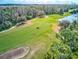 Aerial view of a lush green golf course with trees and a water feature at 2439 Teton Stone Run, Orlando, FL 32828