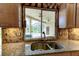 Kitchen sink area featuring granite countertop with view of screened-in outdoor pool area at 2439 Teton Stone Run, Orlando, FL 32828