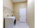 Laundry room with a washing machine, shelving, and tile flooring, providing a convenient and organized space at 2439 Teton Stone Run, Orlando, FL 32828