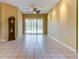 Bright living room with tiled flooring, ceiling fan, and sliding glass doors leading to the pool area at 2439 Teton Stone Run, Orlando, FL 32828