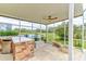 Outdoor kitchen under covered patio with stainless steel grill and refrigerator overlooks a lush golf course at 2439 Teton Stone Run, Orlando, FL 32828