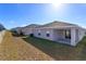 A view of the rear of the house with a covered patio and backyard featuring a grassy lawn at 2447 Matterhorn Trl, Davenport, FL 33837