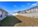 A backyard featuring a grassy lawn, a white fence, and a retaining wall with a black fence at 2447 Matterhorn Trl, Davenport, FL 33837