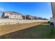 A backyard featuring a lawn with grass and a retaining wall topped with a black fence at 2447 Matterhorn Trl, Davenport, FL 33837