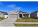 Charming single-story home featuring a well-manicured lawn and an attached two-car garage at 2447 Matterhorn Trl, Davenport, FL 33837