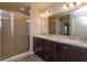 Main bathroom features a double vanity, a tiled shower, and modern fixtures at 2447 Matterhorn Trl, Davenport, FL 33837